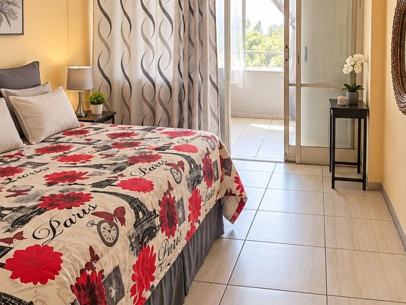 A bedroom featuring tiled flooring and a sliding glass door providing direct access to an outdoor balcony area.
