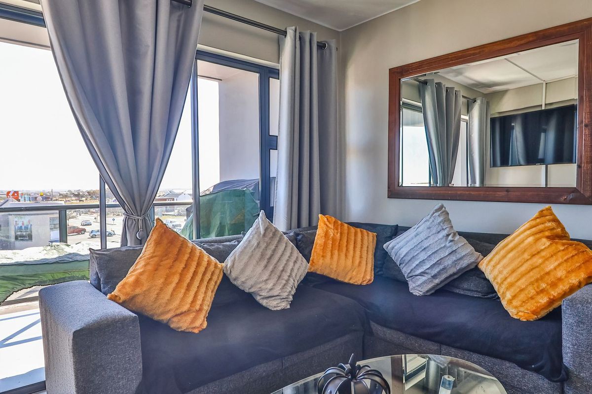 A bright living room featuring large sliding glass doors that provide access to an outdoor balcony and allow for ample natural light.