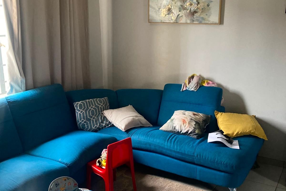 A living room area featuring neutral wall tones and tiled flooring, providing a functional space for relaxation.