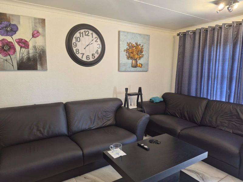 A comfortable living room featuring tiled flooring and classic cove cornicing, providing a neutral foundation for your personal interior design style.