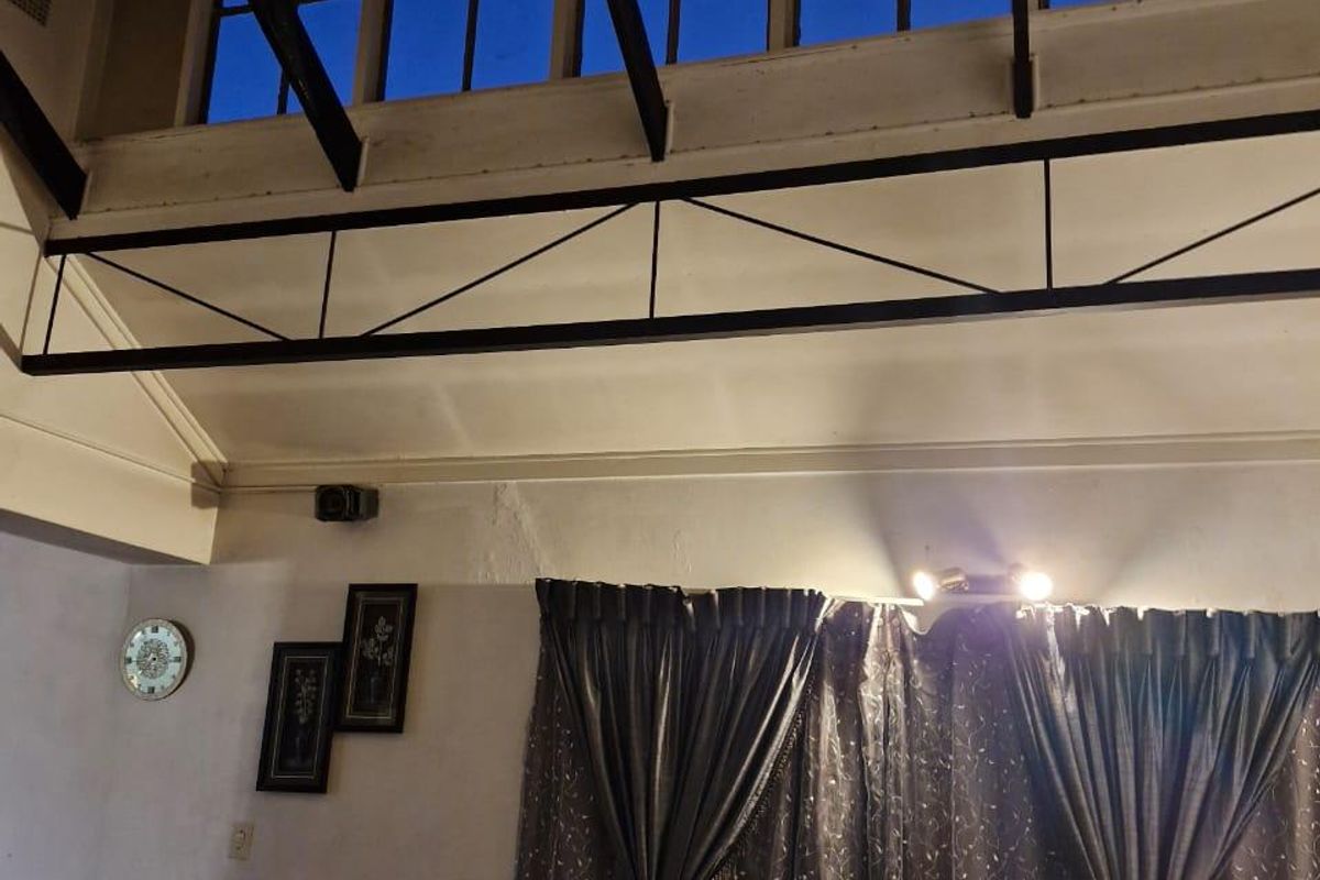 Living room featuring high vaulted ceilings with exposed timber rafters, a decorative steel truss, and clerestory windows providing natural light.