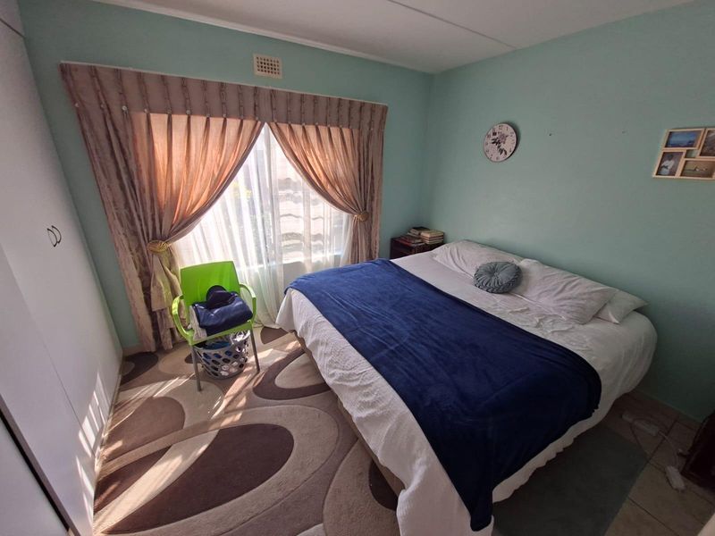 A standard bedroom featuring a built-in wardrobe and natural light through a large window.