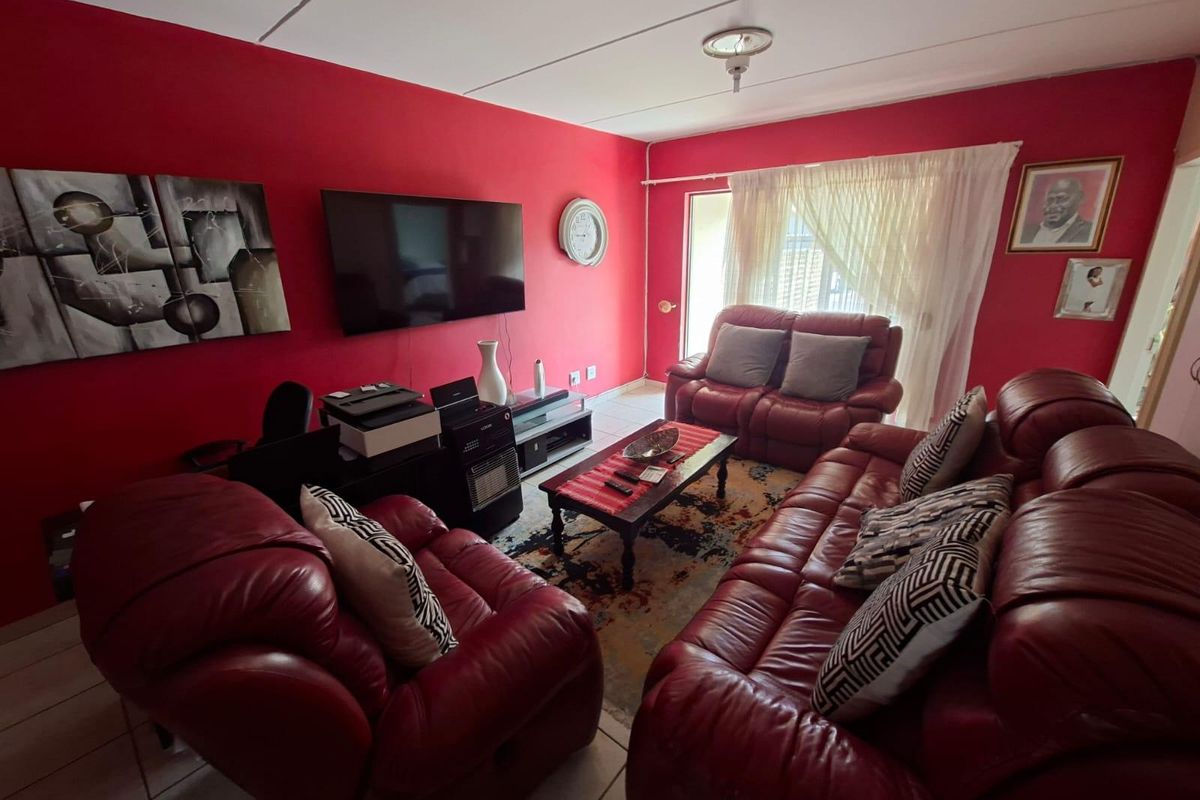 A living room featuring tiled flooring and a sliding glass door providing access to the exterior.