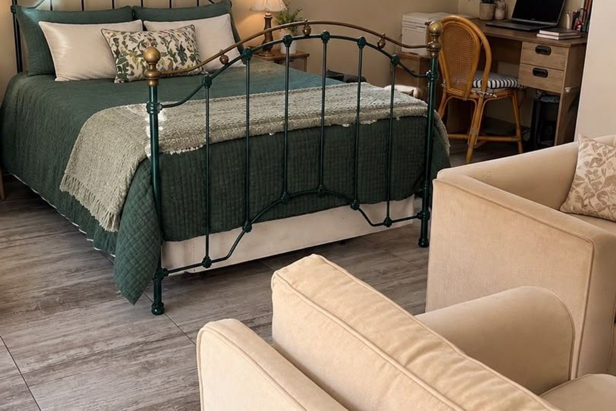 A well-maintained bedroom featuring tiled flooring, a glass block window, and a wall-mounted split-system air conditioning unit.