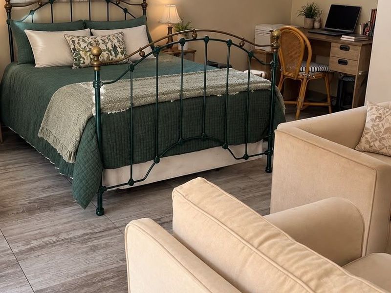 A well-maintained bedroom featuring tiled flooring, a glass block window, and a wall-mounted split-system air conditioning unit.