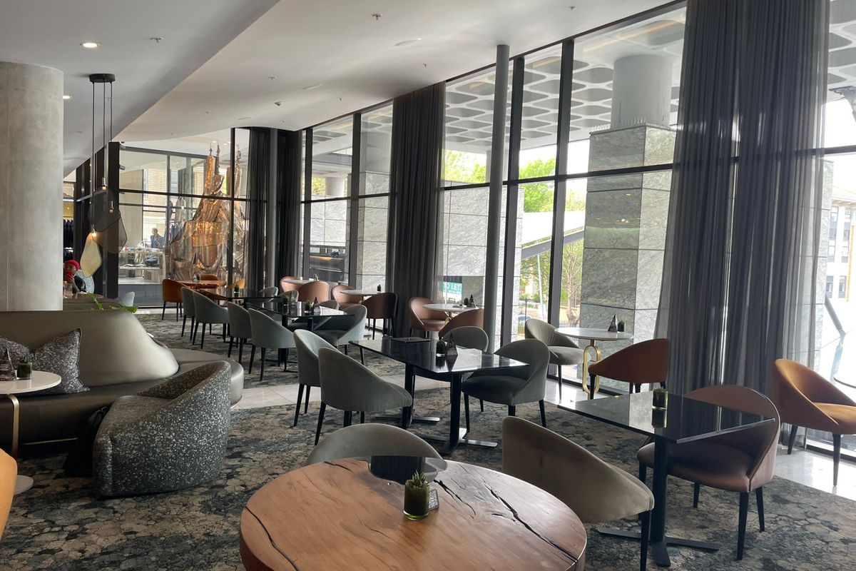 A modern, open-plan living area featuring expansive floor-to-ceiling windows, recessed lighting, and contemporary architectural finishes, creating a bright and sophisticated atmosphere.