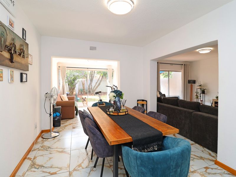 Open plan dining and living area featuring tiled flooring and large sliding glass doors providing access to the rear garden.