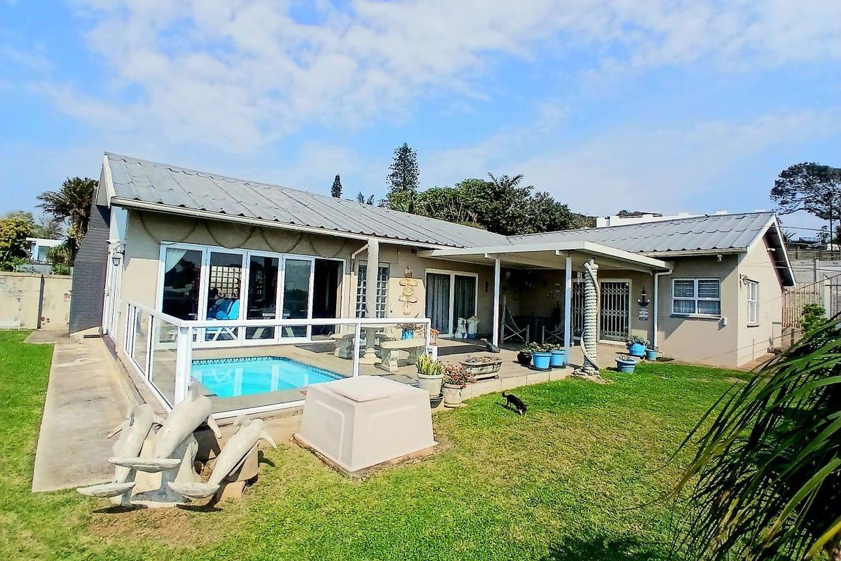 Rear exterior view of the house featuring a swimming pool, covered patio area, and direct access through large glass sliding doors.