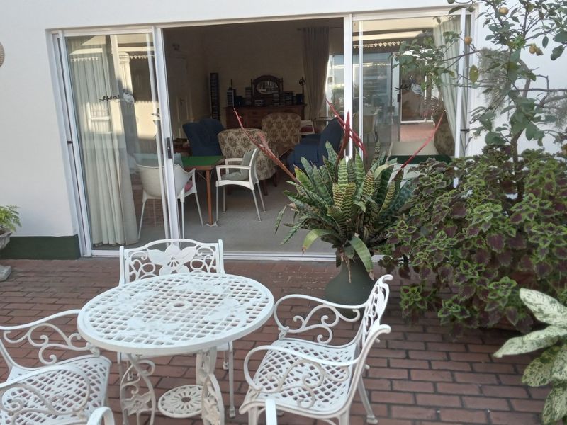 A paved outdoor patio area featuring sliding glass doors that provide seamless access to the interior living space.