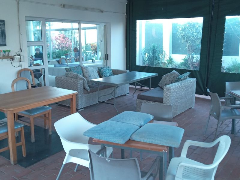 Covered patio area featuring brick flooring and retractable canvas side enclosures, providing a versatile outdoor entertainment space.