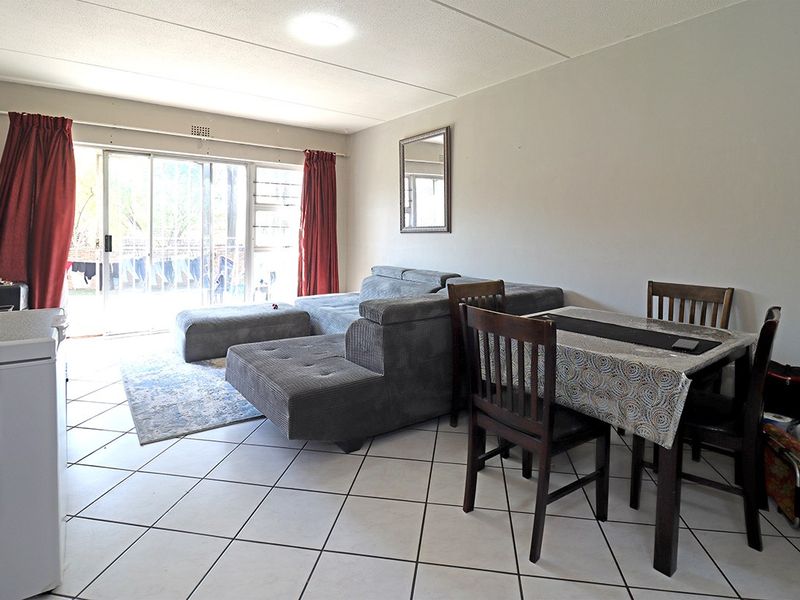 Open plan living and dining area featuring tiled flooring and a large sliding glass door providing access to the outdoor space.