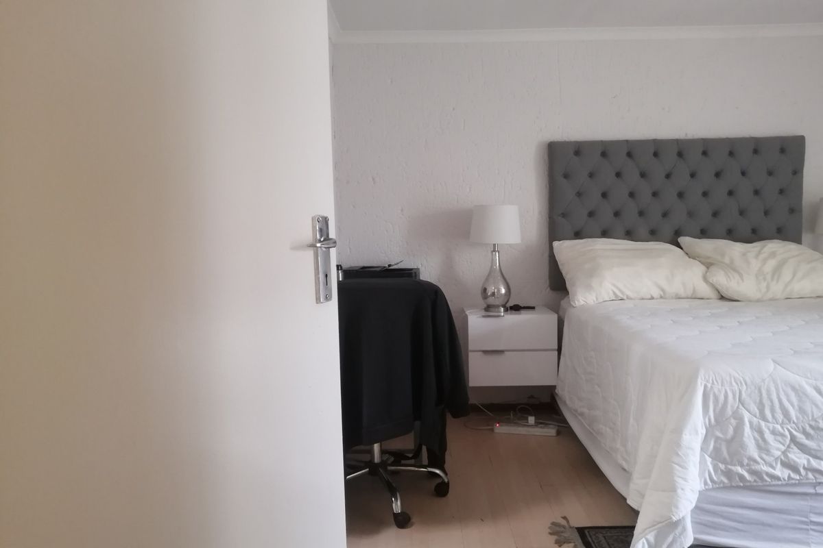 A bedroom featuring laminate flooring and textured walls, viewed from the doorway.