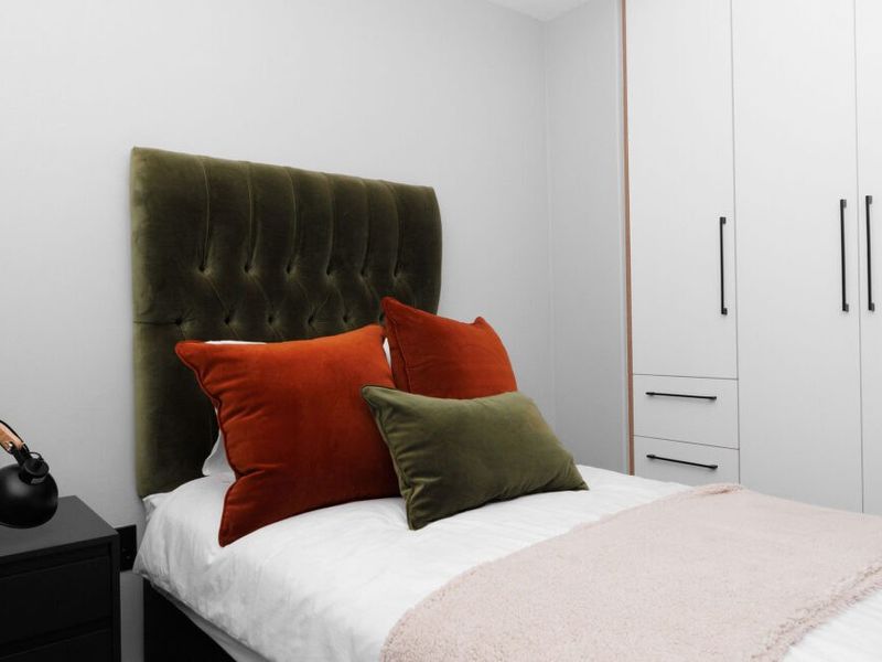A well-maintained bedroom featuring a modern built-in wardrobe with clean lines and contemporary hardware.