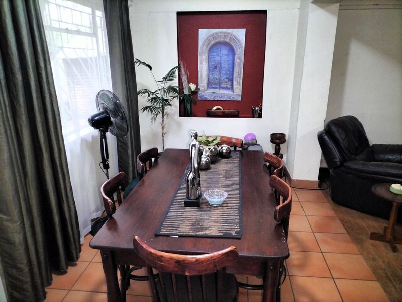 A dining room featuring tiled flooring and a decorative recessed wall niche, providing a functional space for family meals.