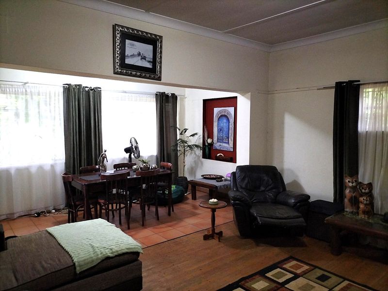 Open plan living and dining area featuring a mix of terracotta tile and timber flooring with a recessed wall niche.
