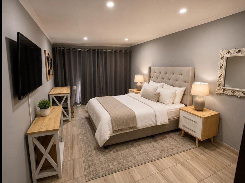 A well-maintained bedroom featuring modern tiled flooring, recessed downlighting, and neutral wall finishes, creating a clean and comfortable living space.