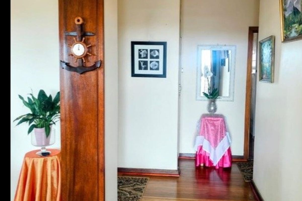 A well-maintained hallway featuring polished hardwood flooring and a prominent timber door frame, providing a warm and inviting transition between living spaces.