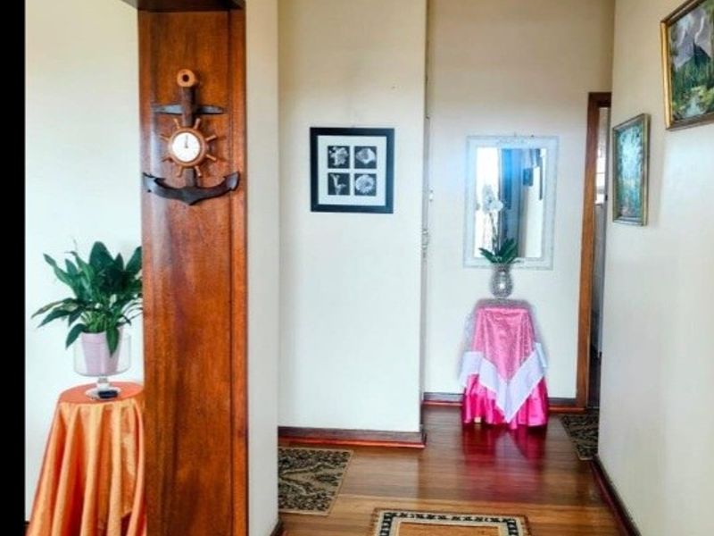 A well-maintained hallway featuring polished hardwood flooring and a prominent timber door frame, providing a warm and inviting transition between living spaces.