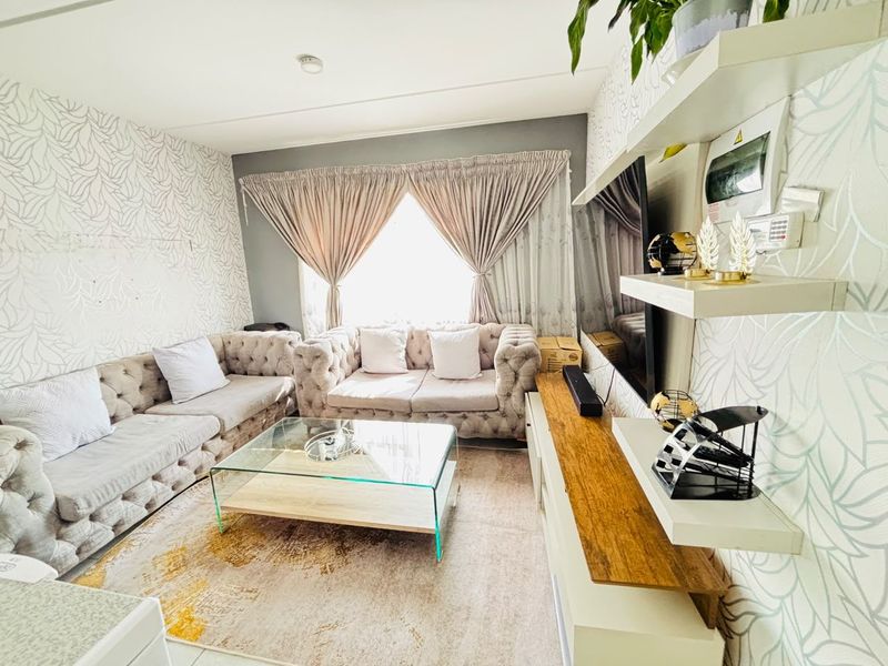A well-maintained living room featuring built-in shelving units and a neutral color palette, providing a comfortable and functional space.
