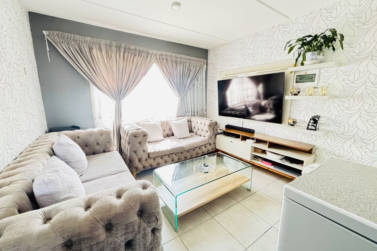 A cozy living room featuring tiled flooring and built-in shelving, providing a functional space for relaxation and entertainment.