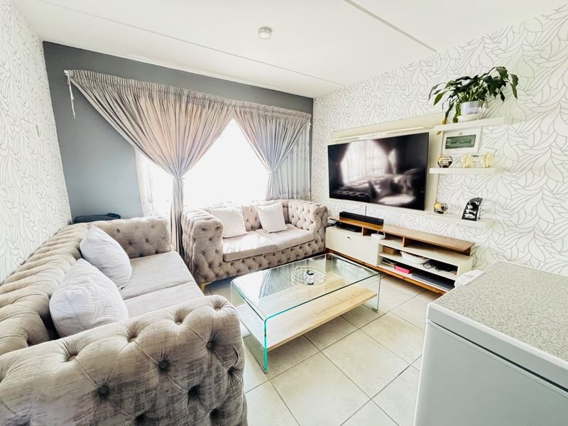 A cozy living room featuring tiled flooring and built-in shelving, providing a functional space for relaxation and entertainment.