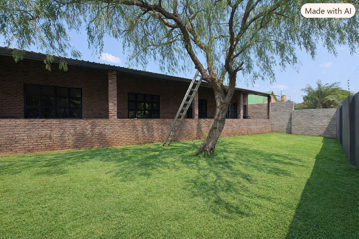 A spacious rear garden featuring a well-maintained lawn, a covered patio with face brick finishes, and black framed windows.