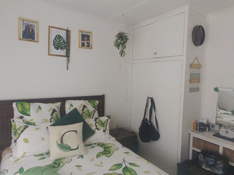 A bedroom featuring a built-in wardrobe with integrated overhead storage cupboards, providing functional storage space.