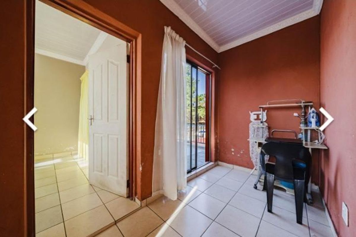A bedroom featuring tiled flooring, a sliding glass door leading to an outdoor area, and a panel door connecting to an adjacent room.