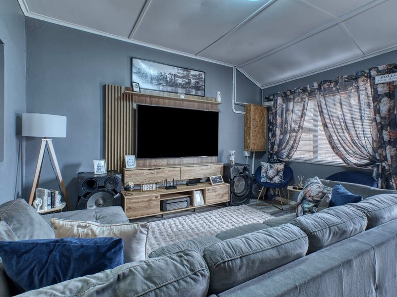 A cozy living room featuring a built-in media wall unit and sloped ceilings, providing a comfortable space for relaxation and entertainment.