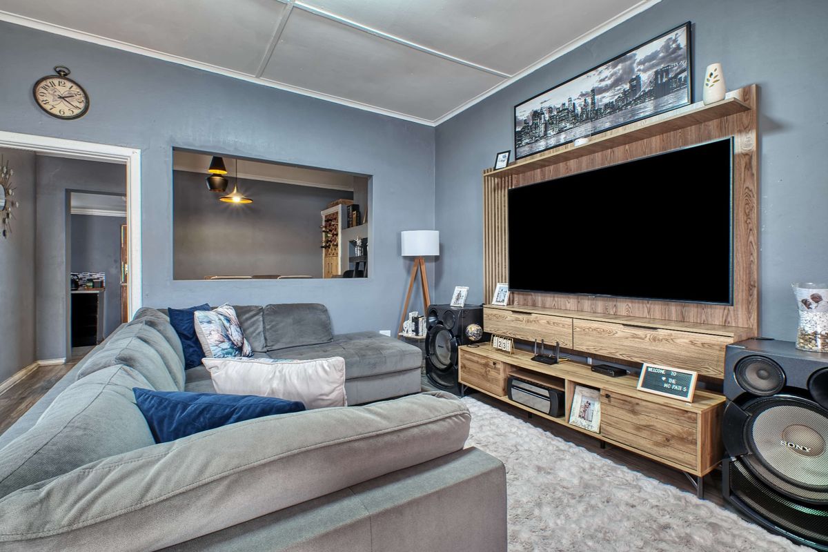 A comfortable living room featuring a custom built-in media unit and a convenient pass-through window connecting to the adjacent space.