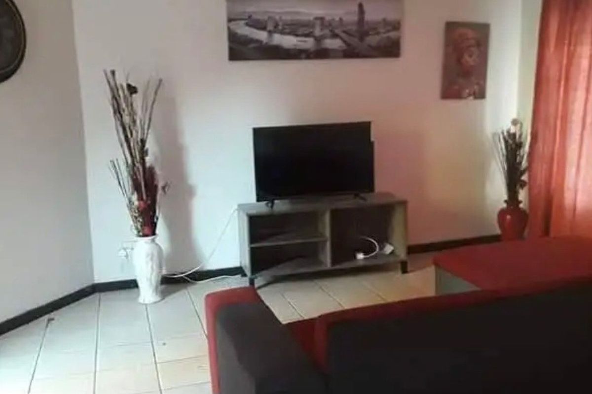 A living room area featuring tiled flooring and neutral wall finishes, providing a functional space for relaxation.