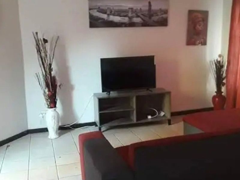A living room area featuring tiled flooring and neutral wall finishes, providing a functional space for relaxation.