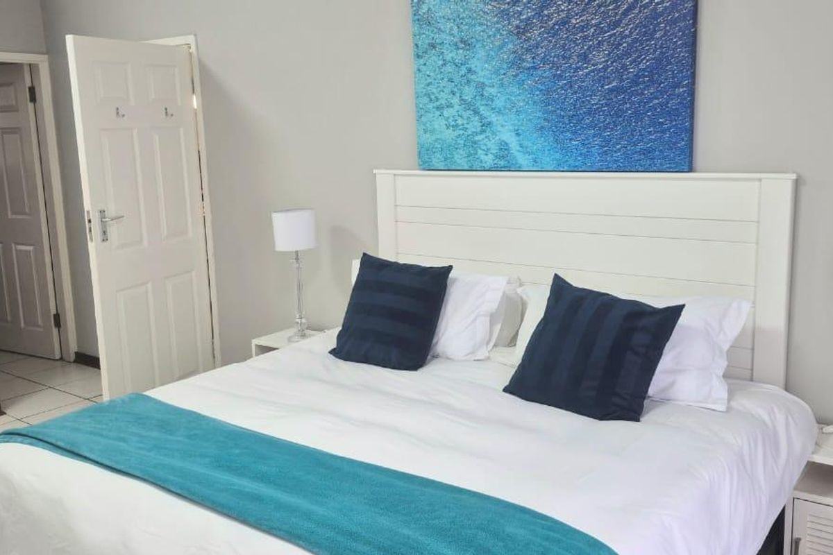 A well-maintained bedroom featuring neutral wall tones, tiled flooring, and built-in storage cabinetry.