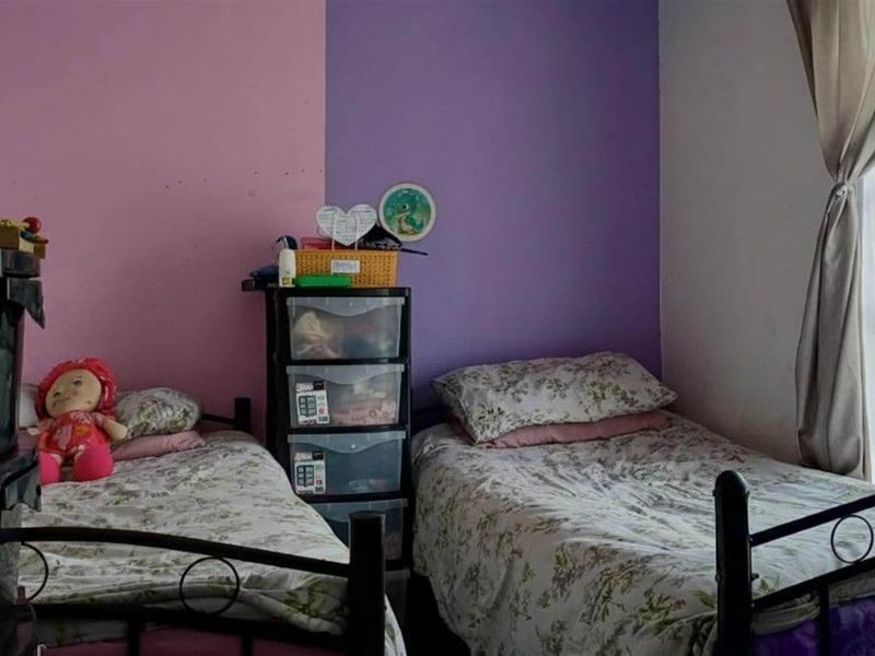 A bedroom featuring dual-tone painted walls and a window with curtains, providing natural light.