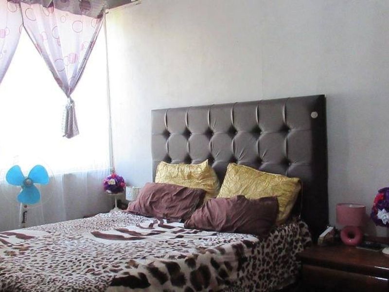 A standard bedroom featuring a large window that provides natural light, creating a functional and comfortable sleeping space.