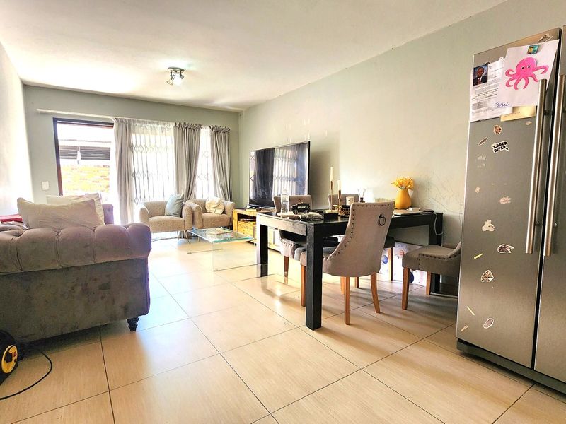 Open-plan living and dining area featuring tiled flooring and a sliding glass door leading to the exterior.
