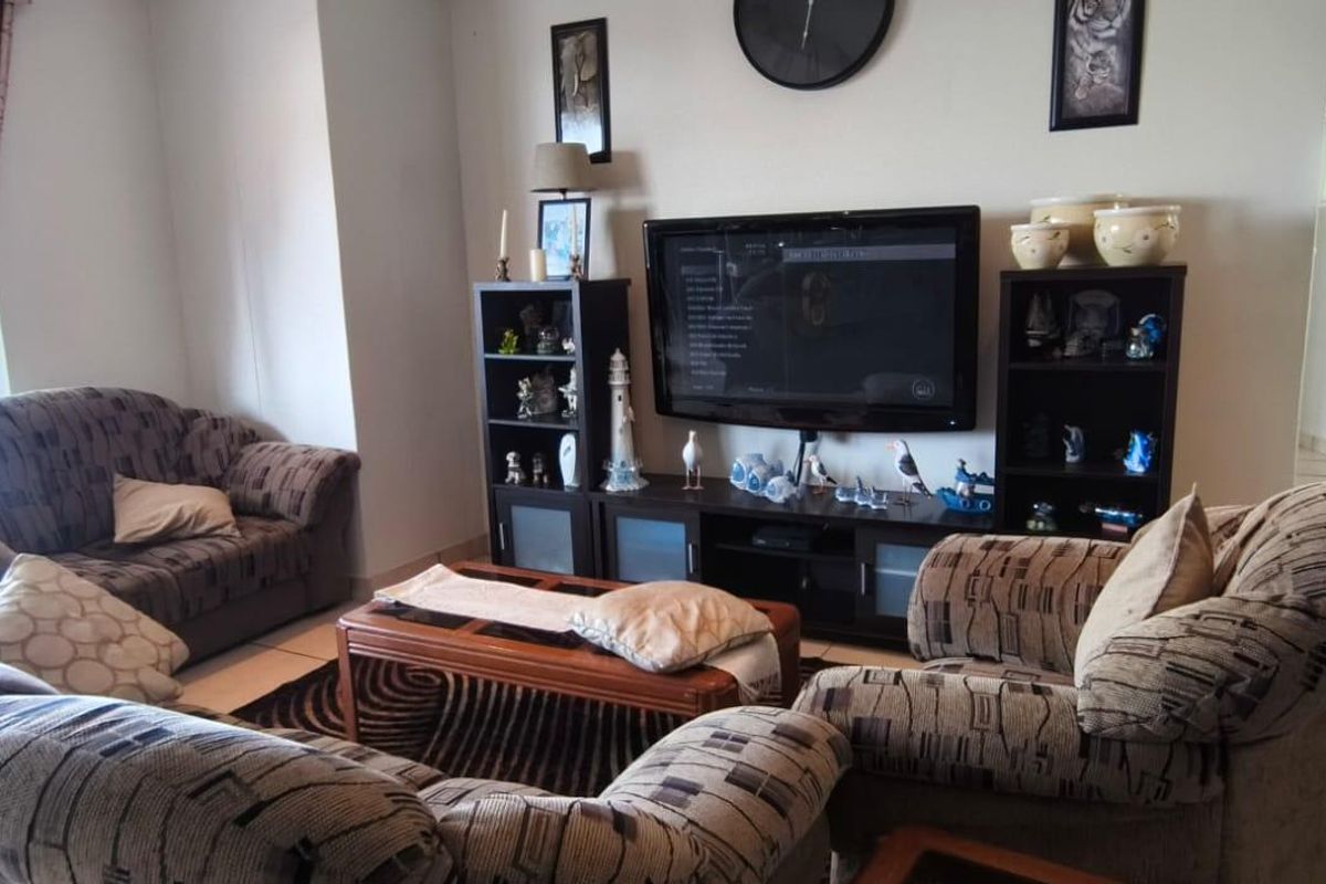 A comfortable living room featuring tiled flooring and a sliding glass door that provides access to an outdoor area.