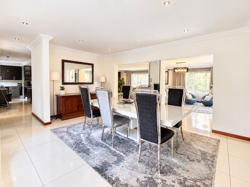 Spacious open-plan dining area featuring polished porcelain tiles, recessed downlighting, and seamless flow into the adjacent kitchen and living spaces.