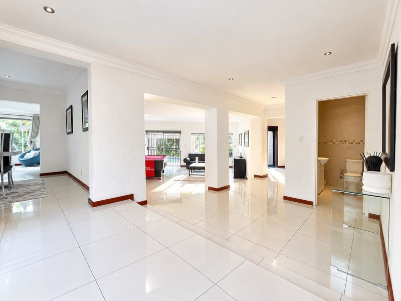 Spacious open-plan living area featuring polished porcelain tiles, recessed lighting, and a convenient guest bathroom, offering a bright and modern flow throughout the home.