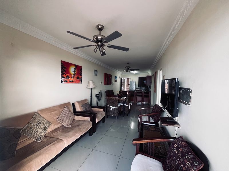 Open plan living and dining area featuring tiled flooring, ceiling fans, and crown molding, creating a functional and connected living space.