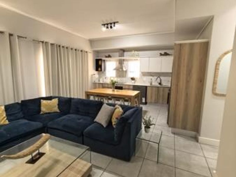 Open-plan living and kitchen area featuring modern cabinetry, tiled flooring, and a functional layout suitable for contemporary apartment living.