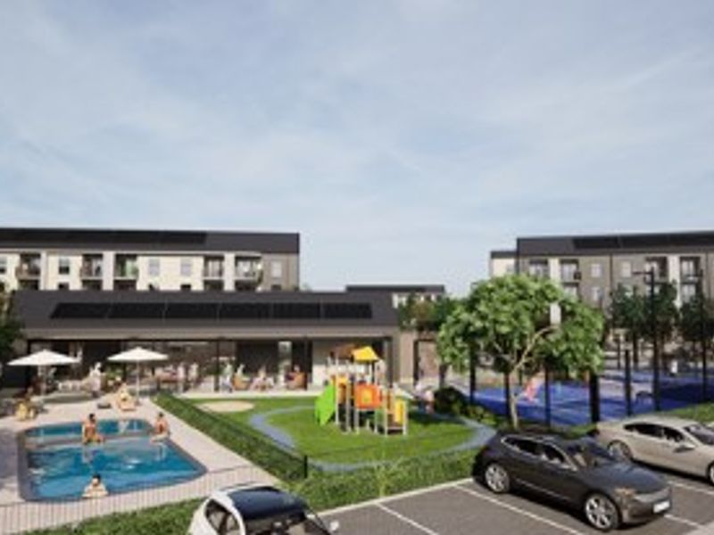 A modern apartment complex communal area featuring a swimming pool, playground, and paved parking facilities with integrated solar panels on the building roofs.