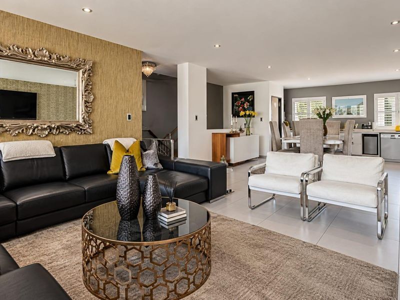 Spacious open-plan living and dining area featuring modern tiled floors, recessed lighting, and a seamless transition to a contemporary kitchen.