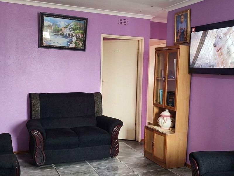 A living room featuring tiled flooring and coved ceilings, currently finished with purple wall paint.