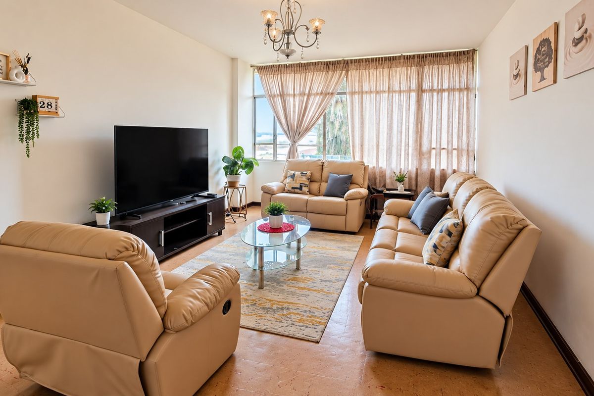 A bright and comfortable living room featuring a large window that allows for ample natural light, creating an inviting and airy atmosphere.