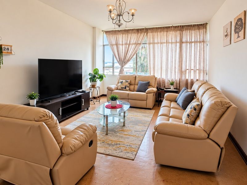 A bright and comfortable living room featuring a large window that allows for ample natural light, creating an inviting and airy atmosphere.