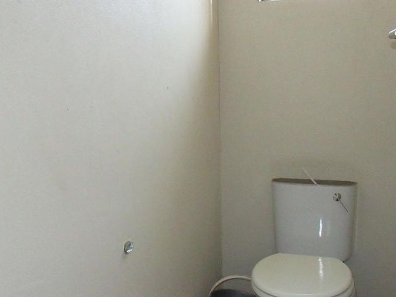 A simple, functional guest toilet or cloakroom featuring basic sanitary ware and neutral wall finishes.