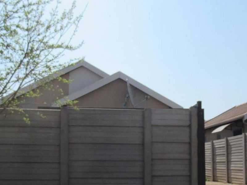 View of the rear exterior showing the property's roofline and precast concrete boundary walling.