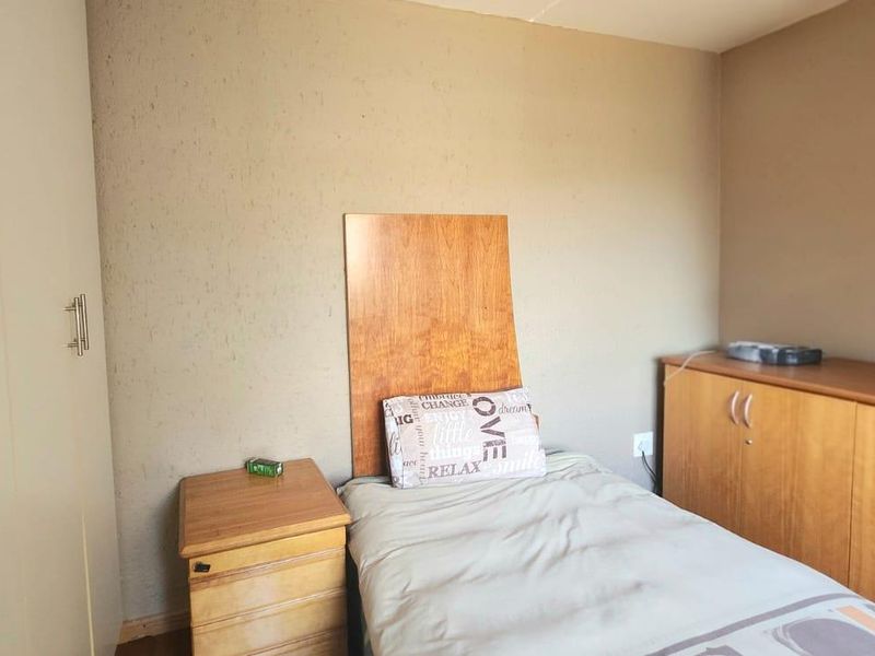 A bedroom featuring built-in wardrobes and additional built-in cabinetry, providing ample storage space within the room.