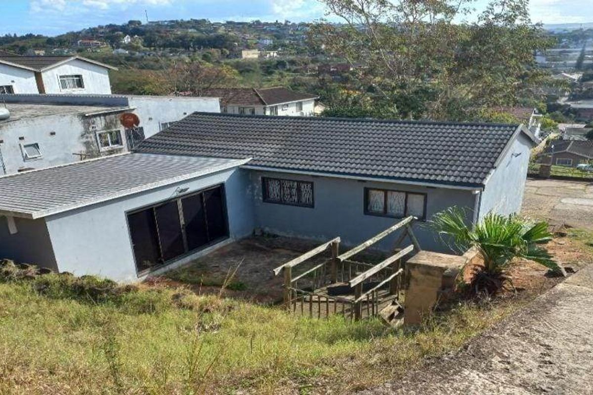 Rear view of the property featuring a tiled roof, sliding glass doors, and an elevated wooden staircase leading to the backyard area.